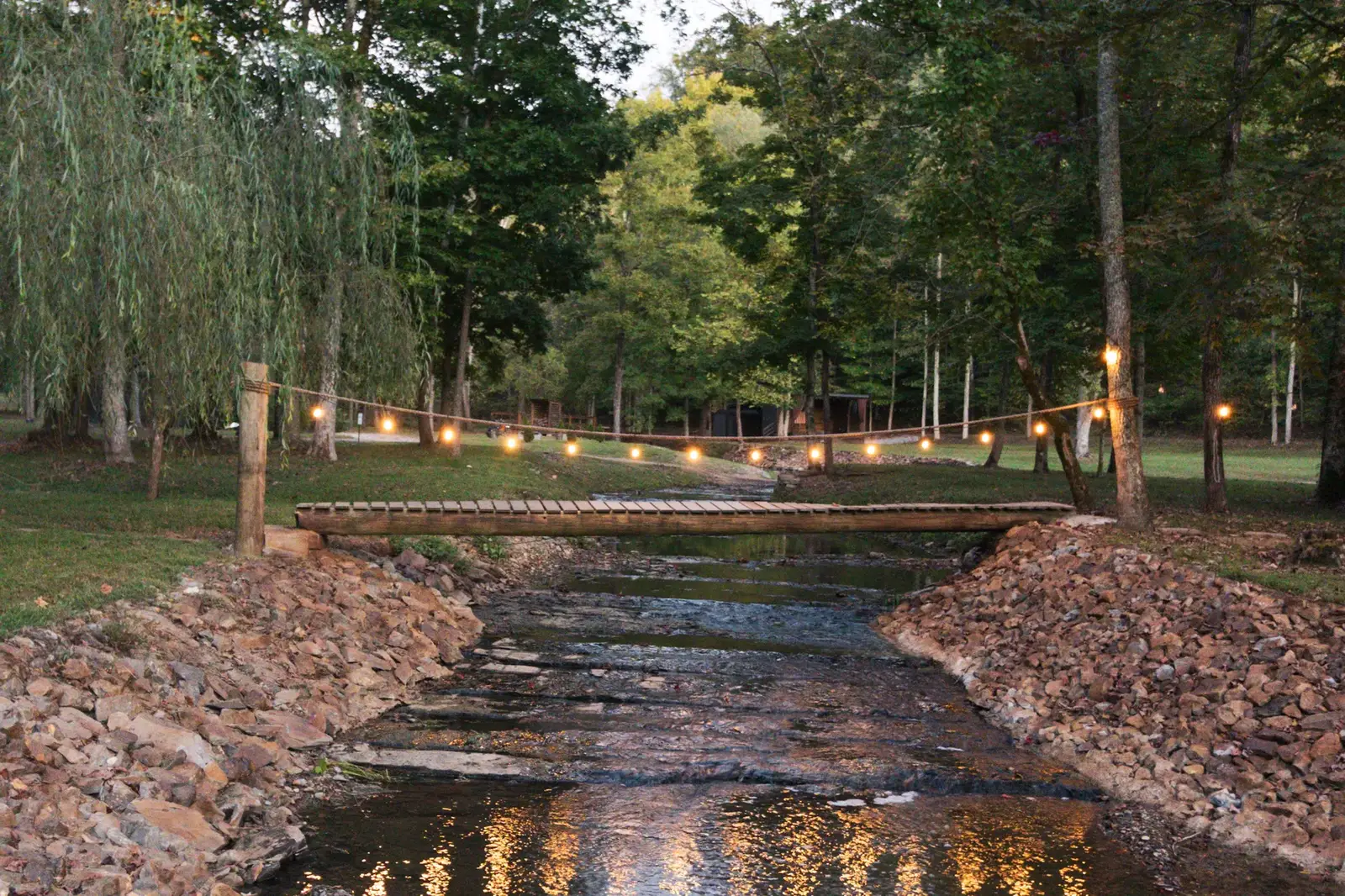 Creek footbridge lit at dusk